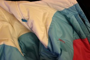 Run your headphones from the chest pocket opening and through the guides up to your ears.